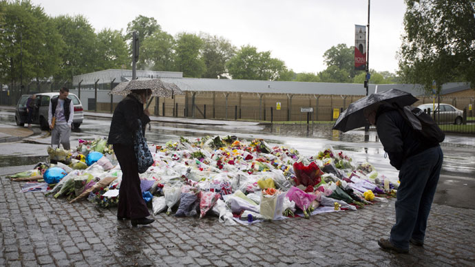 People look at floral tributes left at the scene where Drummer Lee Rigby of the 2nd Battalion was killed outside Woolwich Barracks in London on May 24, 2013.(AFP Photo / Justin Tallis) 