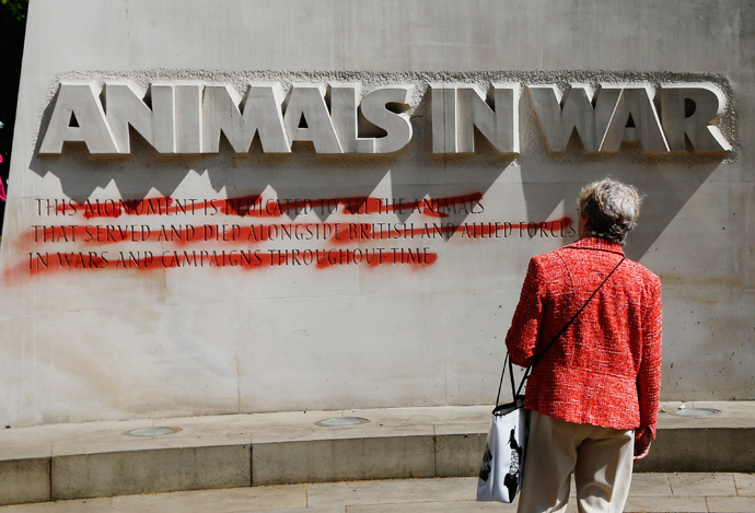 A woman looks at the "Animals at War" memorial, which has been defaced with red paint, in central London May 27, 2013 (Reuters / Luke MacGregor)