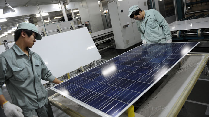 Workers assembling solar panels by hand on the factory floor of Chinese company Suntech in the eastern Chinese city of Wuxi.(AFP Photo / Peter Parks)