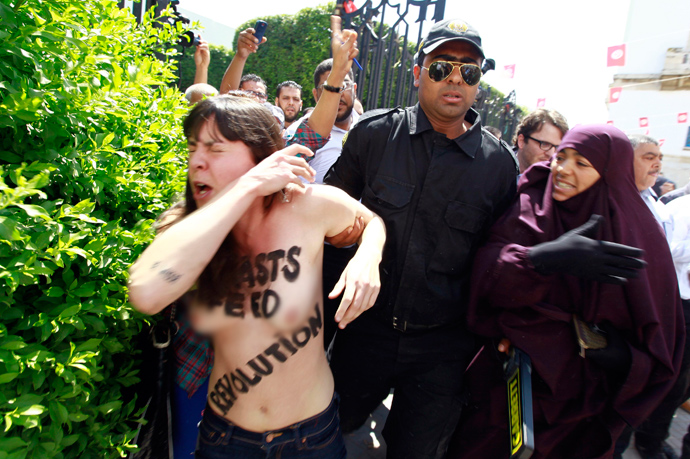 Police officers detain an activist from the women's rights group FEMEN during a protest against the arrest of their Tunisian member named Amina, in front of Tunisia's Ministry of Justice in Tunis, May 29, 2013 (Reuters / Anis Mili) 