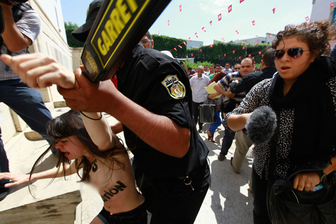 Police officers detain an activist from the women's rights group FEMEN during a protest against the arrest of their Tunisian member named Amina, in front of Tunisia's Ministry of Justice in Tunis, May 29, 2013 (Reuters / Anis Mili) 