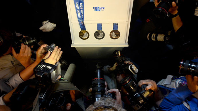 Photographers take pictures of the unveiled Sochi 2014 Olympic (L-R) Gold, Silver and Bronze Medals, as they are displayed during an IOC executive board meeting at the SportAccord International Convention in St. Petersburg, on May 30, 2013.(AFP Photo / Kirill Kudryavtsev)