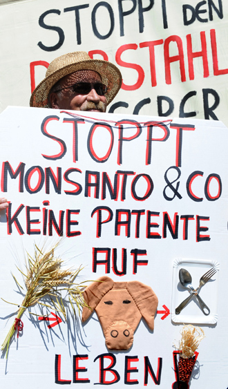 A man protests with placards reading "No patents on on life, stop Monsanto" during a demonstration against food patents in front of the patent office in Munich, southern Germany (AFP Photo)