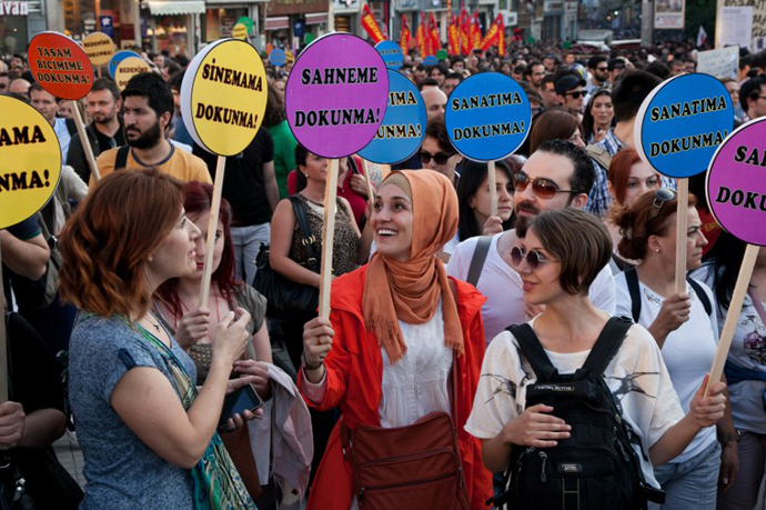 Demonstrators hold placards reading "Dont touch my cinema (L), dont touch my stag e(2nd-L), dont touch my art (R), dont touch my life style (back-R) as they stand during a protest at Taksim square in Istanbul on June 7, 2013. (AFP Photo / Gurcan Ozturk)