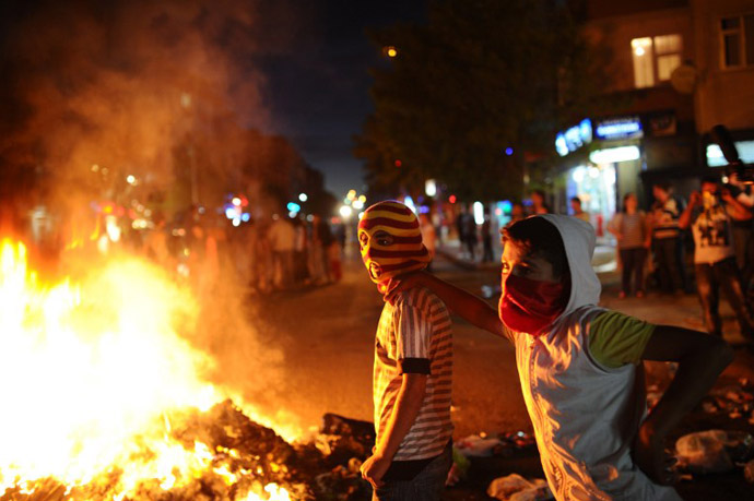 Turkish boys stand next to burning trash during a clashes in the Gazi district of Istanbul on June 11, 2013. (AFP Photo / Bulent Kilic)