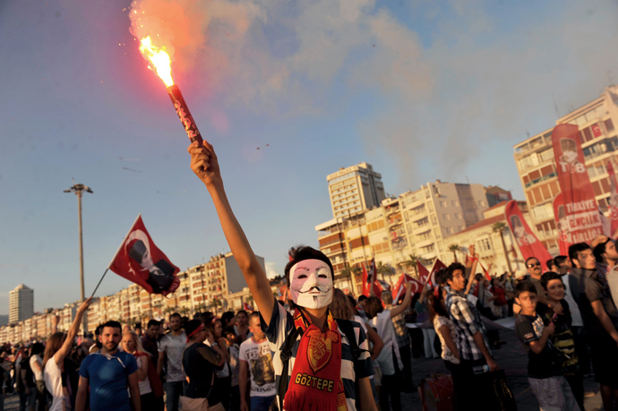 A Turkish demostrator burns flares with a Guy Fawkes mask on June 8, 2013 during a demonstration on Gundogdu square in Izmir (AFP Photo / Ozan Kose)