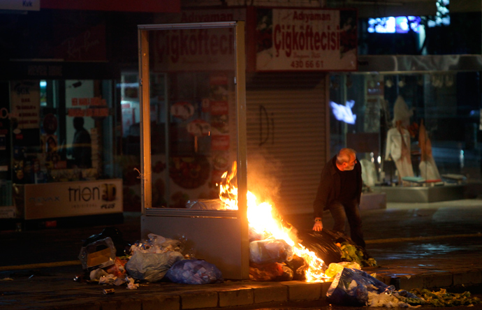 A protester places some trash into a fire in central Ankara, June 9, 2013 (Reuters / Dado Ruvic)