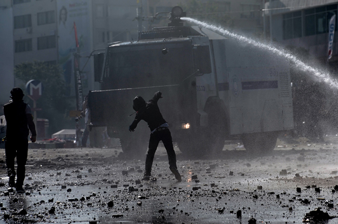 A protester throws a stone at a water canon during clashes with riot police in istanbul's Taksim square on June 11, 2013 (AFP Photo/ Aris Messinis) 