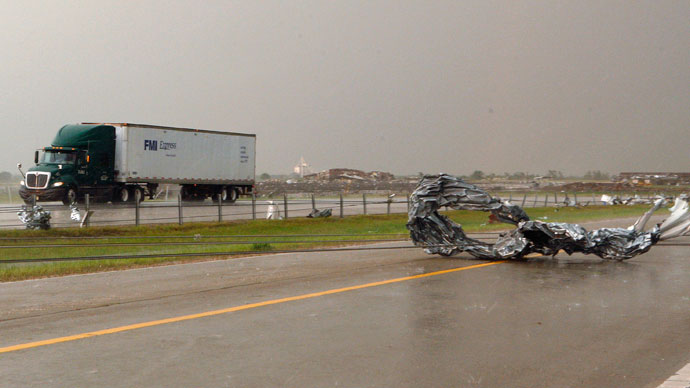 Tornado debris and downed power lines are seen at Interstate-40 Westbound as traffic slowly passes in the opposite direction of Interstate-40, just east of El Reno, Oklahoma May 31, 2013.(Reuters / Bill Waugh)