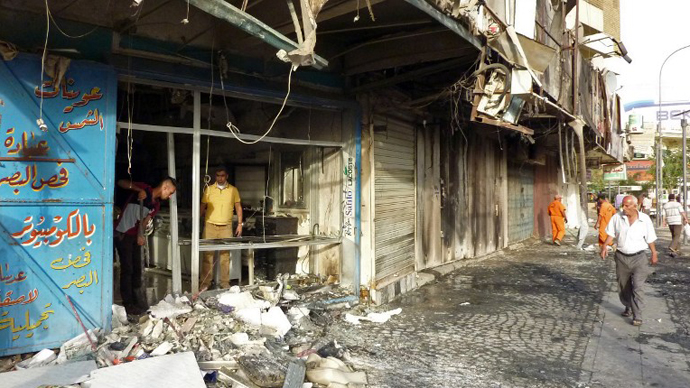 Iraqis inspect the damage following a car bomb attack in Baghdad's commercial Sadoun Street on May 27, 2013. (AFP Photo / Ali Al-Saadi)
