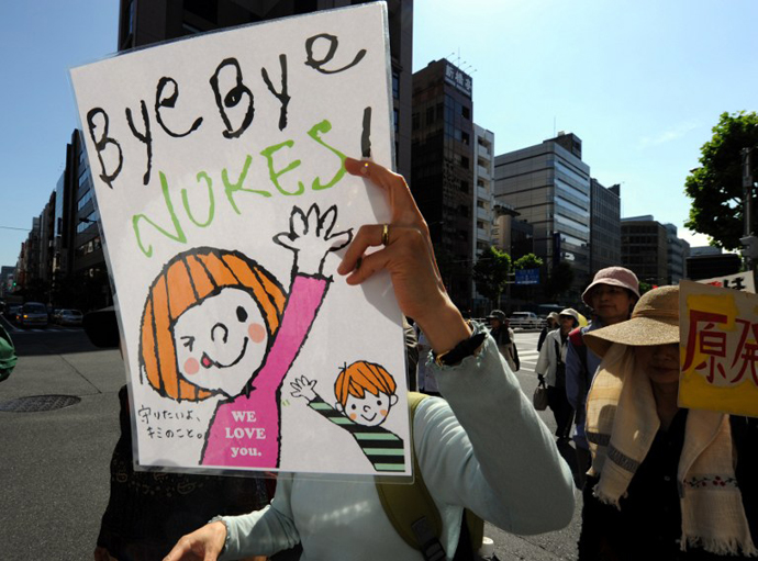 A protestor holds a banner during a protest march against nuclear power plants, following the March 2011 Fukushima meltdown-disasters, in Tokyo on June 2, 2013. (AFP Photo / Toshifumi Kitamura)