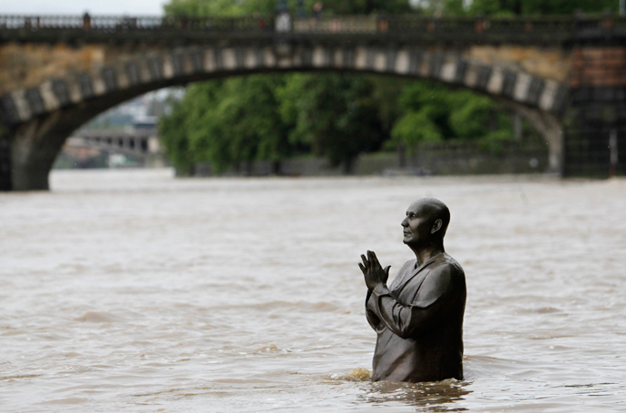 The statue of world harmony leader Sri Chinmoy is partially submerged in water from the rising Vltava river in Prague June 2, 2013 (Reuters / David W Cerny) 