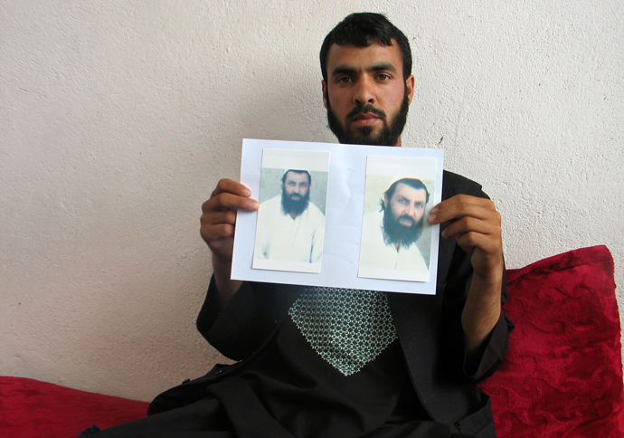 Shahedullah, 24, holds pictures of his brother Mohammad Qasim, whose body according to Shahedullah was found close to the COP Nerkh military base, in Wardak province (Reuters / Stringer)