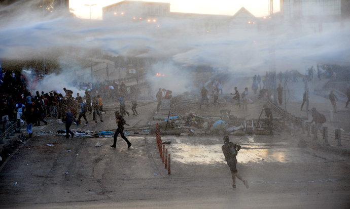 Protestor clash with Turkish riot police using water cannons between Taksim and Besiktas in Istanbul on June 3, 2013 during a demonstration against the demolition of the park (AFP Photo / Bulent Kilic) 