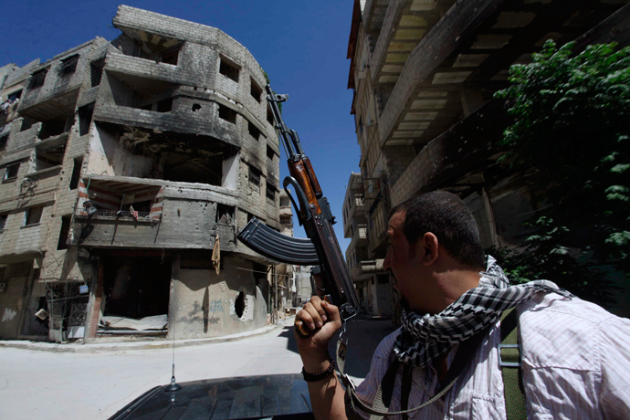 A Shi'ite fighter holds his weapon while patrolling a road at Sayeda Zainab area in Damascus (Reuters / Alaa Al-Marjani) 