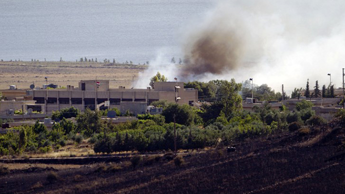 A picture taken from the Israeli side of the Israel-Syria ceasefire line in the Golan Heights shows smoke billowing from a fire caused by clashes between Syrian rebels and forces loyal to the regime on June 7, 2013 near the Quneitra crossing. (AFP Photo / Ahmad Gharabli)