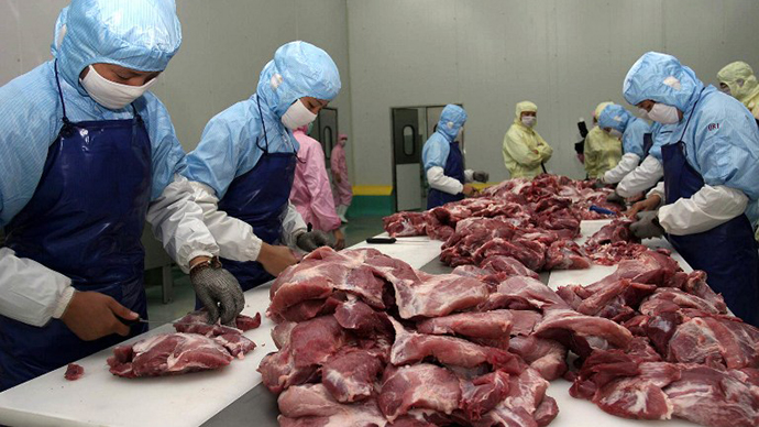 Workers cut up meat at a sausage factory in Xiamen, southeastern China's Fujian province. (AFP Photo)