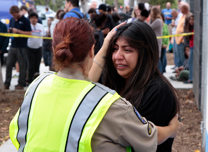 A women is comforted by a traffic officer near Santa Monica College following a shooting today on the campus in Santa Monica, California, June 7, 2013 (Reuters / Jonathan Alcorn)