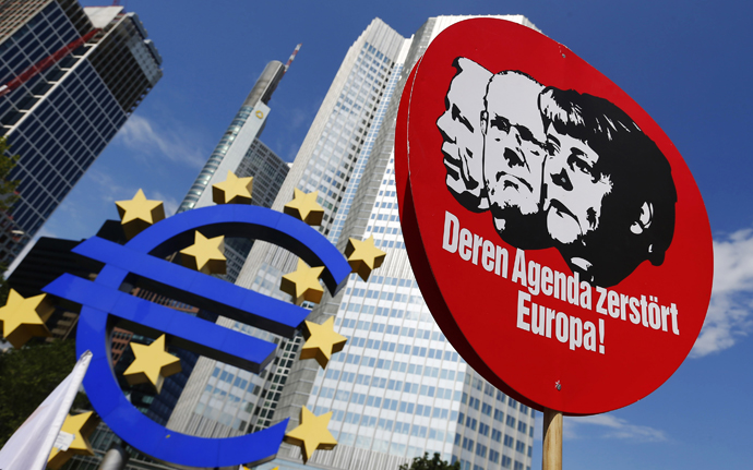 A sign depicting German Chancellor Angela Merkel (R) and other politicians is seen next to the Euro currency sign outside the European Central Bank (ECB) during a protest in Frankfurt, June 8, 2013. (Reuters / Ralph Orlowski )