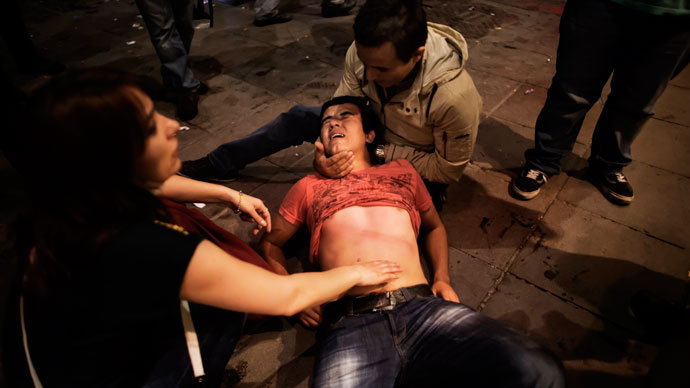 A beaten and shocked demonstrator cries in pain on June 9, 2013.(AFP Photo / Marco Longari)