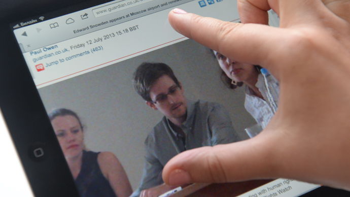A journalist looks at a display with a picture of former CIA employee Edward Snowden (RIA Novosti)