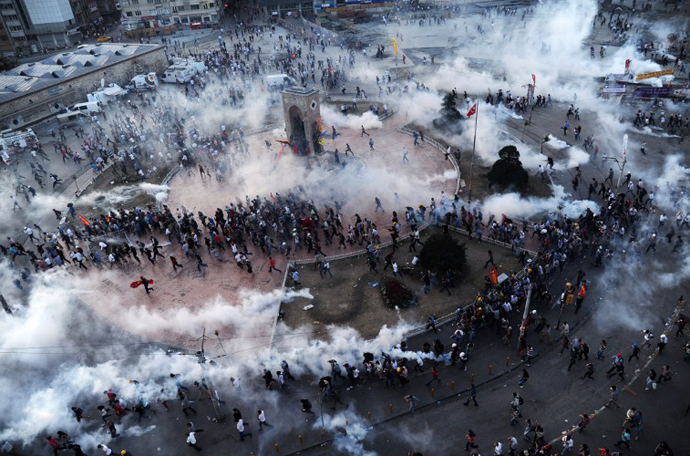 People run away as Turkish riot policemen fire tear gas on Taksim square on June 11, 2013. (AFP Photo / Bulent Kilic)
