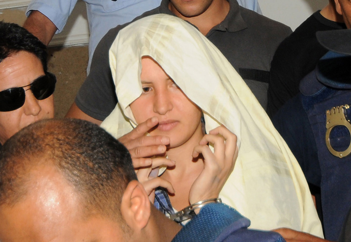 Amina Sboui (C), the Tunisian member of the Ukrainian feminist group Femen, appears handcuffed with a cloth over her head before an investigating judge at the courthouse of the central city Tunisian of Kairouan (AFP Photo)