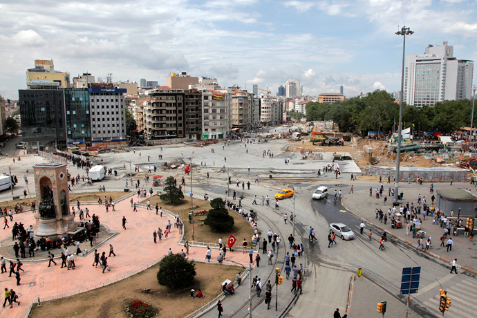 People walk at Istanbul Taksim square on June 12, 2013 after a large clean-up operation removed all evidence of the unrest, clearing the square of stray tear gas canisters, anti-Erdogan banners and makeshift barricades (AFP Photo / Gurcan Ozturk)