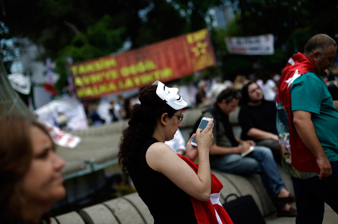 A protester uses her mobile device as she walks at Gezi Park on Taksim Square in Istanbul (Reuters / Stoyan Nenov) 