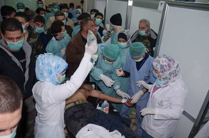 In this image made available by the Syrian News Agency (SANA) on March 19, 2013, medics and other masked people attend to a man at a hospital in Khan al-Assal in the northern Aleppo province, as Syria's government accused rebel forces of using chemical weapons for the first time. (AFP Photo / SANA)