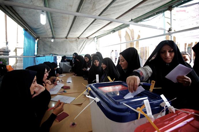 Female Iranian election officials check the IDs of the women voters as they cast their ballots during the first round of the presidential election at a polling station in Shah Abdolazim mausoleum, in southern Tehran, on June 14, 2013. (AFP Photo)