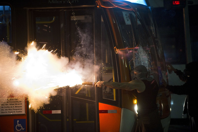 A demonstrator aims a flare at riot police during a demonstration in downtown Sao Paulo, Brazil on June 13, 2013, against a recent rise in public bus and subway fare from 3 to 3.20 reais (1.50 USD). (AFP Photo/Nelson Almeida)