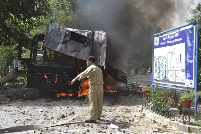 A firefighter stands near a burning bus after a bomb attack in Quetta June 15, 2013. (Reuters/Naseer Ahmed)
