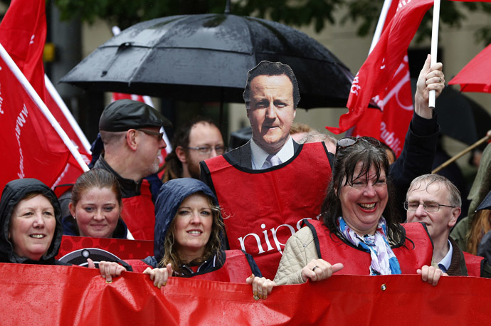 A demonstrator holds a placard depicting Britain Prime Minister David Cameron (C) during a protest against the upcoming G8 summit, to be held near Enniskillen, in Belfast June 15, 2013. (Reuters)
