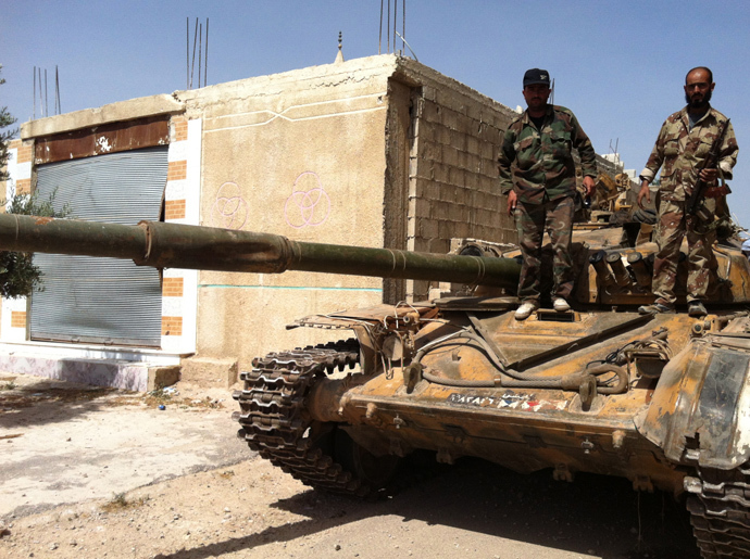 Syrian army soldiers standing on an army tank in the village of Buweida, north of Qusayr, in Syria's central Homs province (AFP Photo / Str)