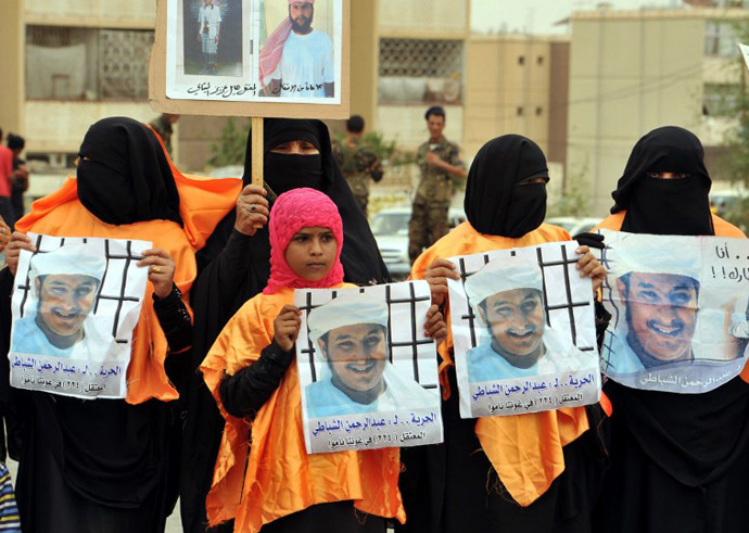 Relatives of Yemeni prisoner Abdel Rahman al-Shabati being held at the US-run Guantanamo Bay detention camp hold his pictures during a demonstration calling for the release of prisoners outside the US embassy in Sanaa on June 17, 2013. (AFP Photo / Gamal Noman)