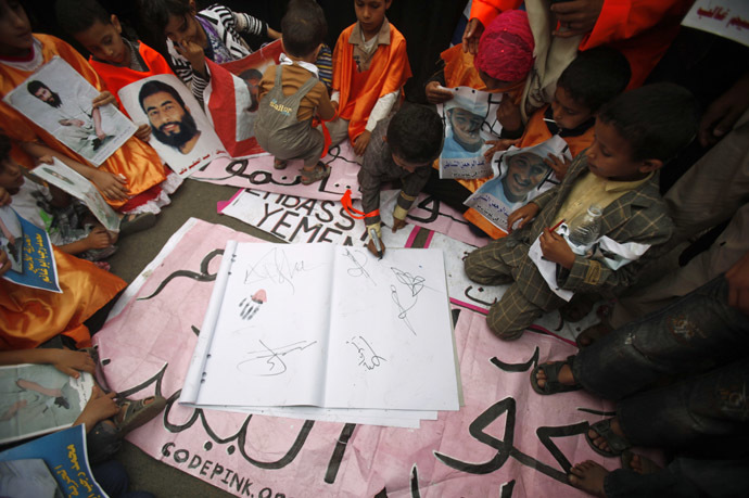 A boy, who is a relative of a Yemeni detainee at Guantanamo Bay prison, signs a letter demanding the closure of the prison, outside the U.S. embassy in Sanaa June 17, 2013. (Reuters / Khaled Abdullah Ali Al Mahdi)