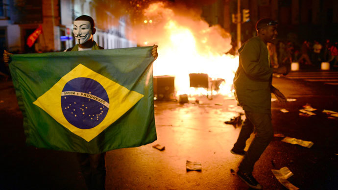 A demonstrator holds a Brazilian national flag during a protest turned violent, in downtown Rio de Janeiro on June 17, 2013. (AFP Photo / Christophe Simon)