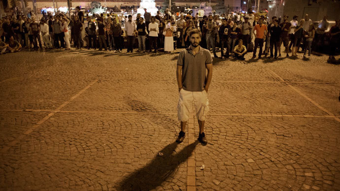 A man emulates Turkish choreographer Erdem Gunduz by standing on Taksim square for a lone protest June 18, 2013.(AFP Photo / Marco Longari)