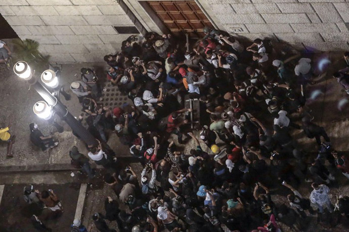 Students try to break down a door of the City Hall building in Sao Paulo, Brazil on June 18, 2013. (AFP Photo / Miguel Schincariol)