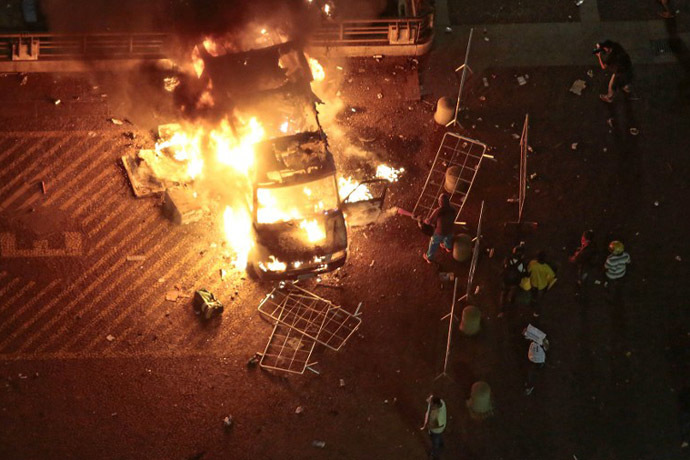 A vandalized press car from TV Record burns during a student demonstration in front of the City Hall in Sao Paulo, Brazil on June 18, 2013. (AFP Photo / Miguel Schincariol)