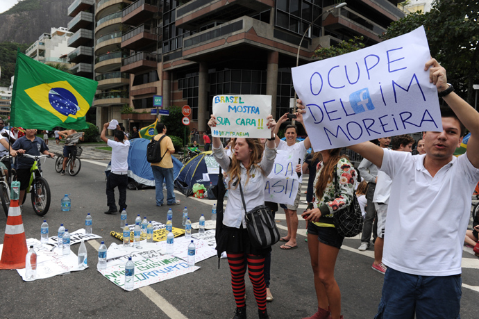 Protesters camping, since last night, in front of the residence of Rio de Janeiro's governor Sergio Cabral, in Leblon, Rio de Janeiro, hold signs while blocking the street on June 22, 2013 (AFP Photo / Tasso Marcleo)