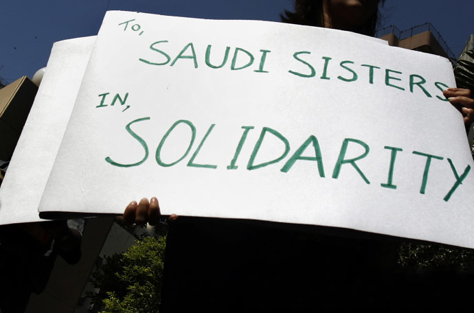 A human rights activist holds a banner during a protest. (Reuters / Arko Datta)