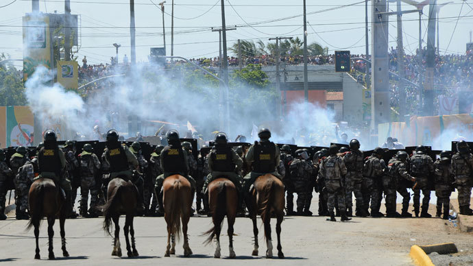 Riot police officers clash with protesters who blocked access to the Castelao Stadium in Fortaleza, where Brazil is to play Mexico in a FIFA Confederations Cup Brazil 2013 football match, to denounce the events' $15 billion price-tag, on June 19, 2013.(AFP Photo / Vanderlei Almeida)