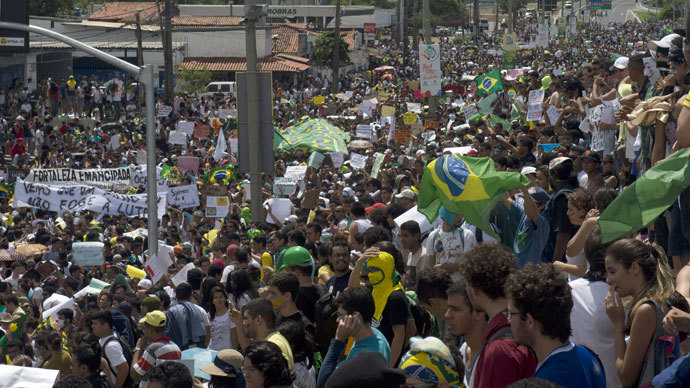 Protesters demonstrate as a group clashes with the riot police while trying to block access to the Castelao Stadium in Fortaleza, where Brazil is to play Mexico in a FIFA Confederations Cup Brazil 2013 football match, to denounce the events' $15 billion price-tag, on June 19, 2013.(AFP Photo / Yuri Cortez)