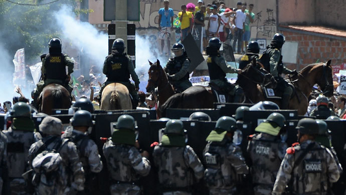 Riot police officers clash with protesters who blocked access to the Castelao Stadium in Fortaleza, where Brazil is to play Mexico in a FIFA Confederations Cup Brazil 2013 football match, to denounce the events' $15 billion price-tag, on June 19, 2013.(AFP Photo / Vanderlei Almeida)