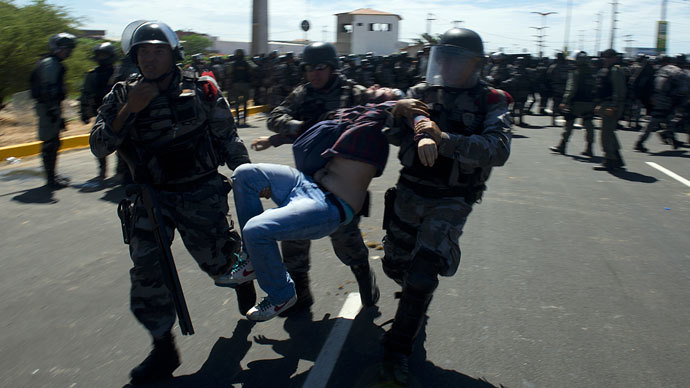 Anti-riot police officers carry a wounded demonstrator as clashes erupt in Fortaleza on June 19, 2013 .(AFP Photo / Yuri Cortez)