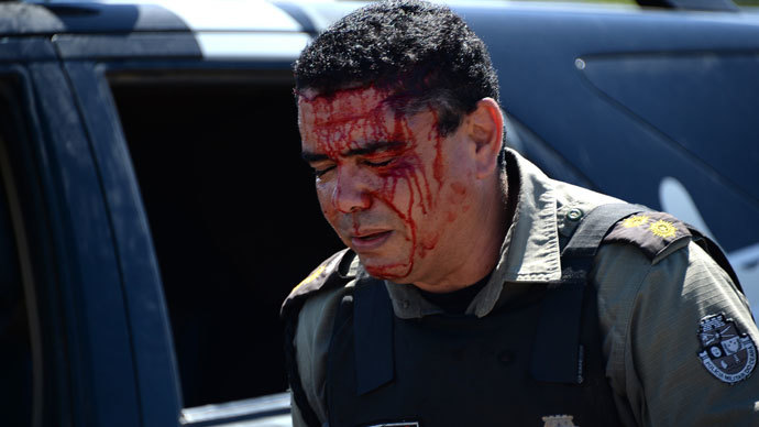 An anti-riot police officer walks in a street of Fortaleza after being injured during a protest against corruption and price hikes on June 19, 2013.(AFP Photo / Vanderlei Almeida)
