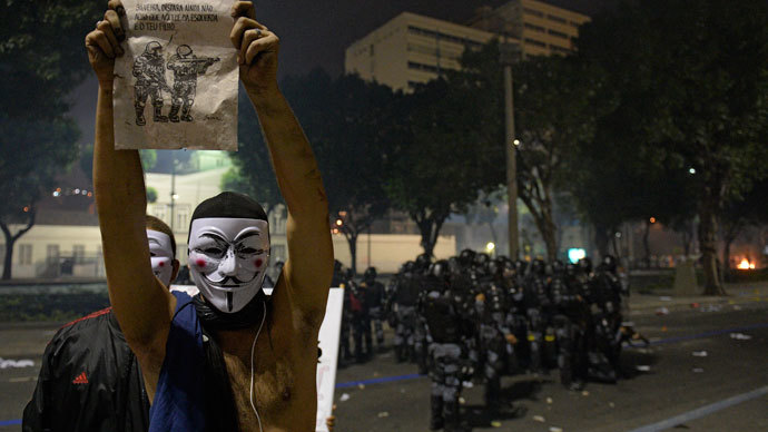 A man demonstrates near riot police officers after clashes erupted during a protest against corruption and price hikes, on June 20, 2013, in Rio de Janeiro. (AFP Photo / Lluis Gene)