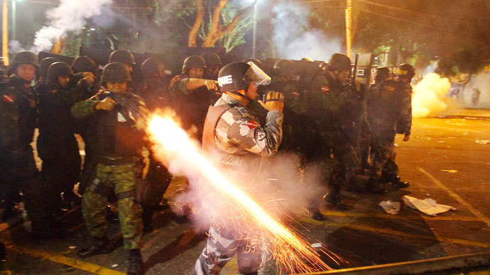 A riot policeman fires his weapon while confronting stone-throwing demonstrators during an anti-government protest in Belem, at the mouth of the Amazon River, June 20, 2013. (Reuters / Ney Macondes)